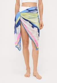 Foulard stampato colorato con design di onde oceaniche, principalmente blu, verde e rosa, realizzato in tessuto leggero e fluido, che mostra una consistenza morbida.