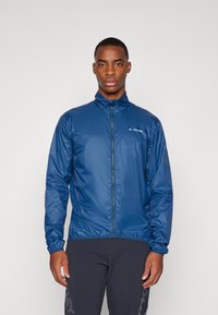 Navy blue lightweight jacket with a stand-up collar and full zip, featuring a smooth texture and elastic cuffs. Logo printed on the chest.