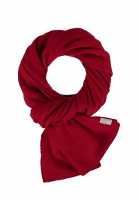 Echarpe tricotée rouge, design circulaire avec un tissu torsadé. Texture douce, finition lisse, et une petite étiquette de marque visible sur un côté.