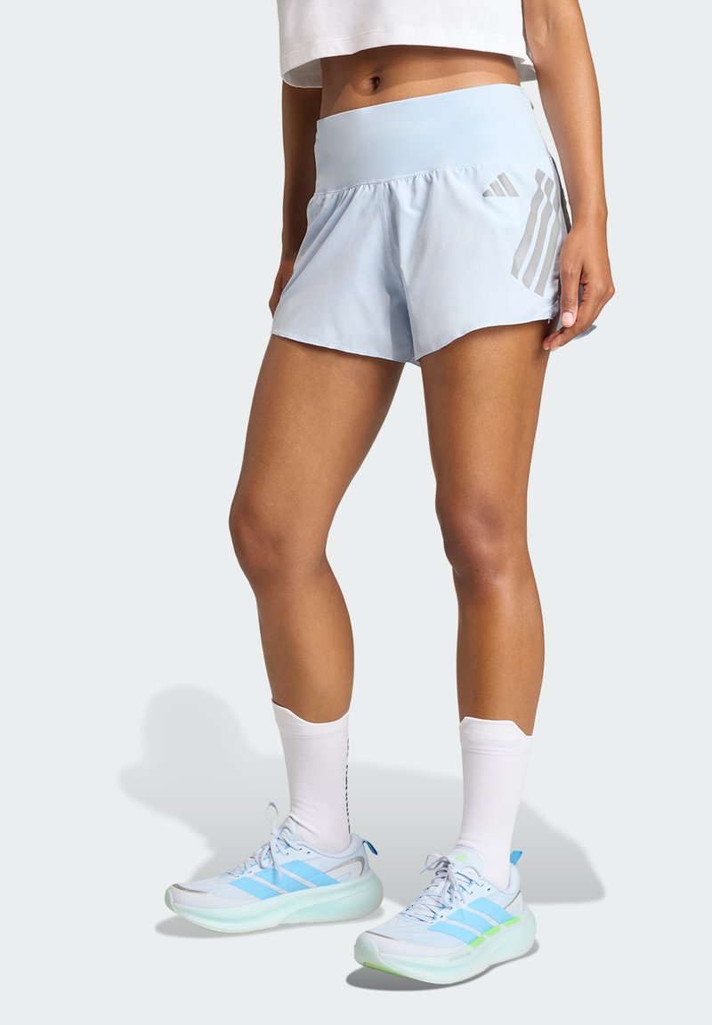 Svetlo modre tekaške kratke hlače z širokim pasom, s stranskimi naborki in vzorcem treh navpičnih črt v temnejši modri barvi.