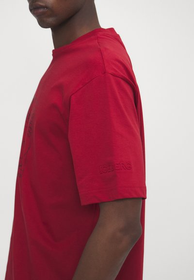 Rotes Baumwoll-T-Shirt mit kurzen Ärmeln, rundem Halsausschnitt und gesticktem "ICEBERG"-Detail auf dem linken Ärmel.