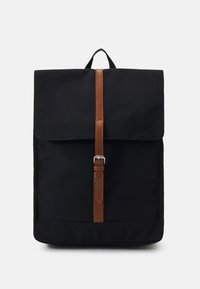 Black backpack with a fold-over flap, secured by a brown leather strap and silver buckle. Made of durable fabric, featuring a clean rectangular shape.