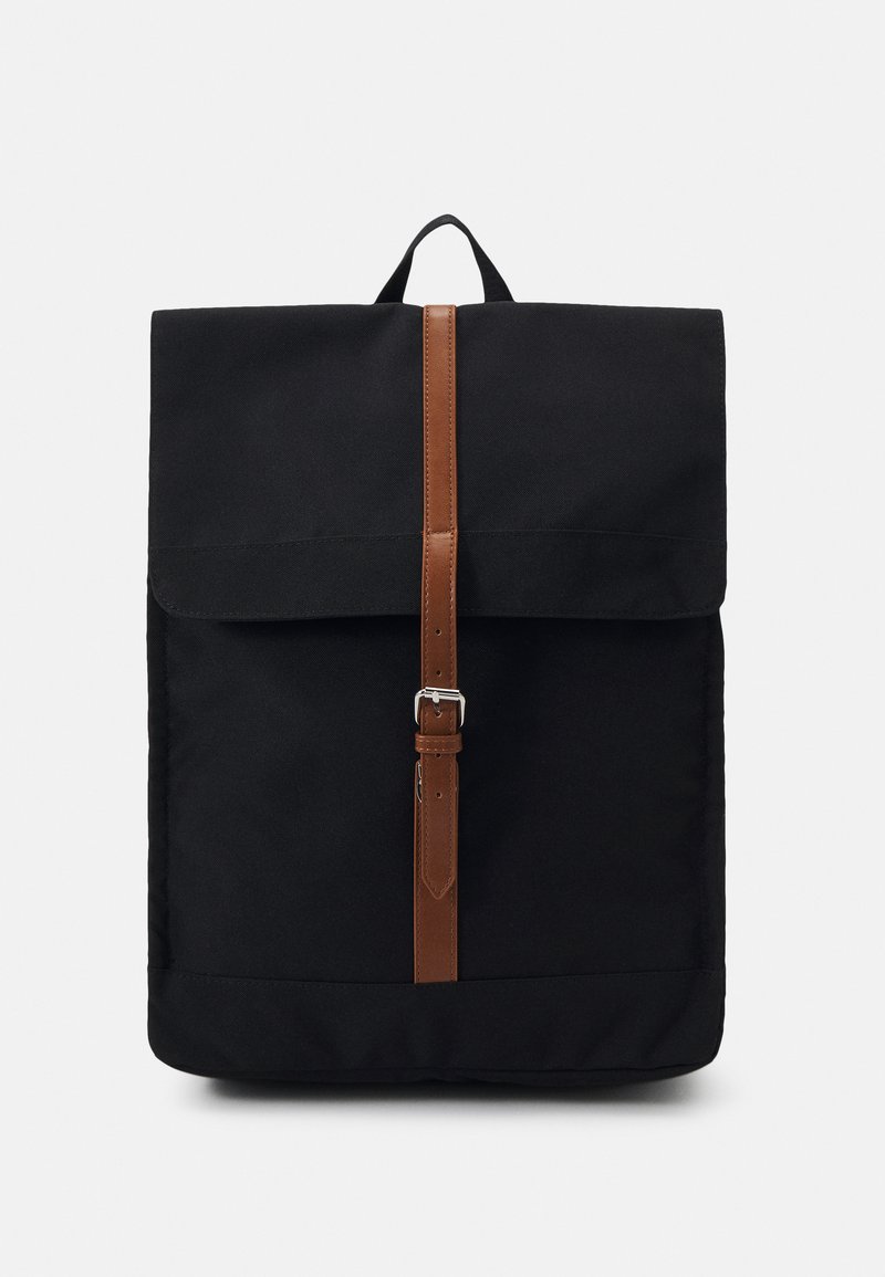 Black backpack with a fold-over flap, secured by a brown leather strap and silver buckle. Made of durable fabric, featuring a clean rectangular shape.