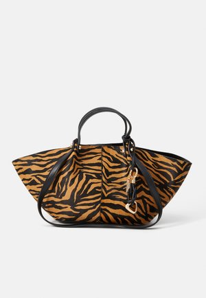 Tote-tasken har et sort og orange tigerstribet mønster, lavet af tekstureret stof med sorte læderhåndtag og en hardware-accent i guldfarve.