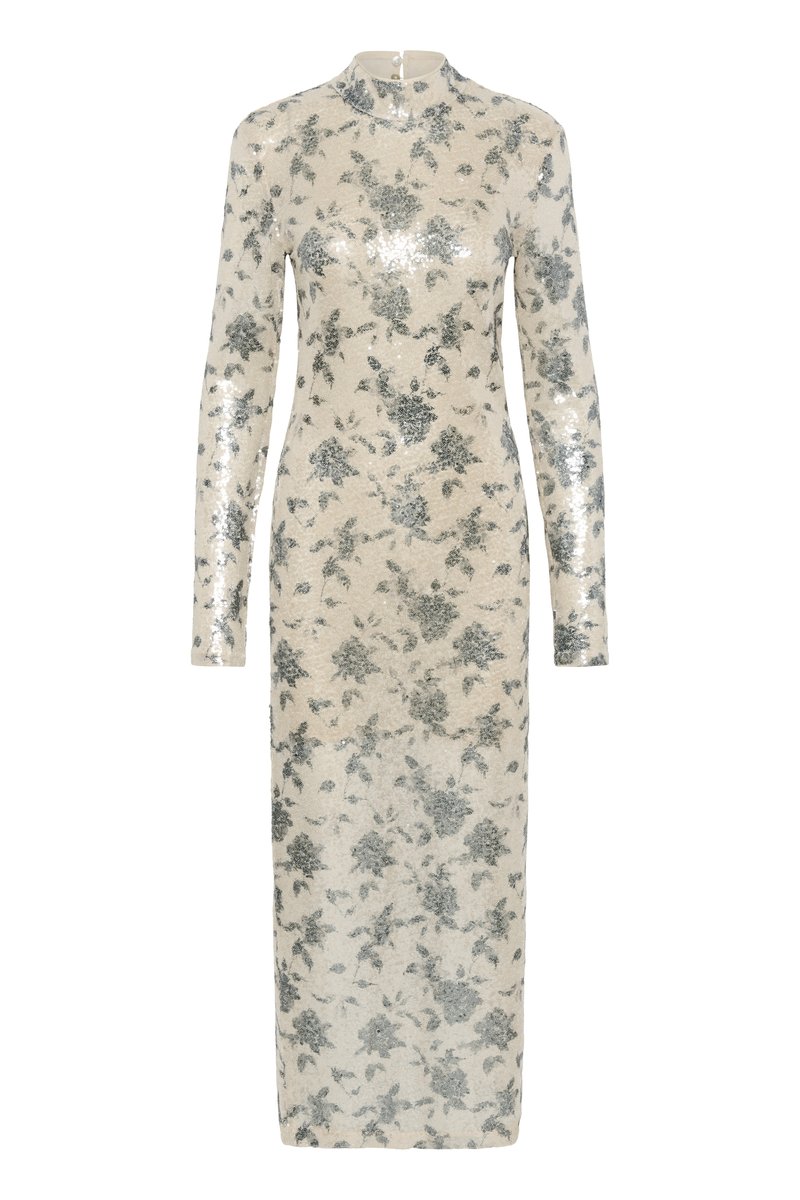 Langrouw jurkje in crème met metallic zilveren bloemsequins, hoge halslijn en rechte silhouet, dat tot halverwege de kuit reikt. Ritsluiting aan de achterkant.