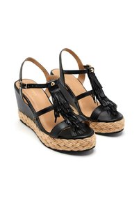 Sandalias de cuña negras con suela de yute trenzado, que presentan un diseño con tiras y detalles decorativos de borlas.