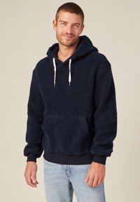 Hoodie en polaire bleu marine avec une texture douce, capuche à cordon, poche kangourou à l'avant et poignets et ourlet côtelés. Design décontracté, longueur moyenne.