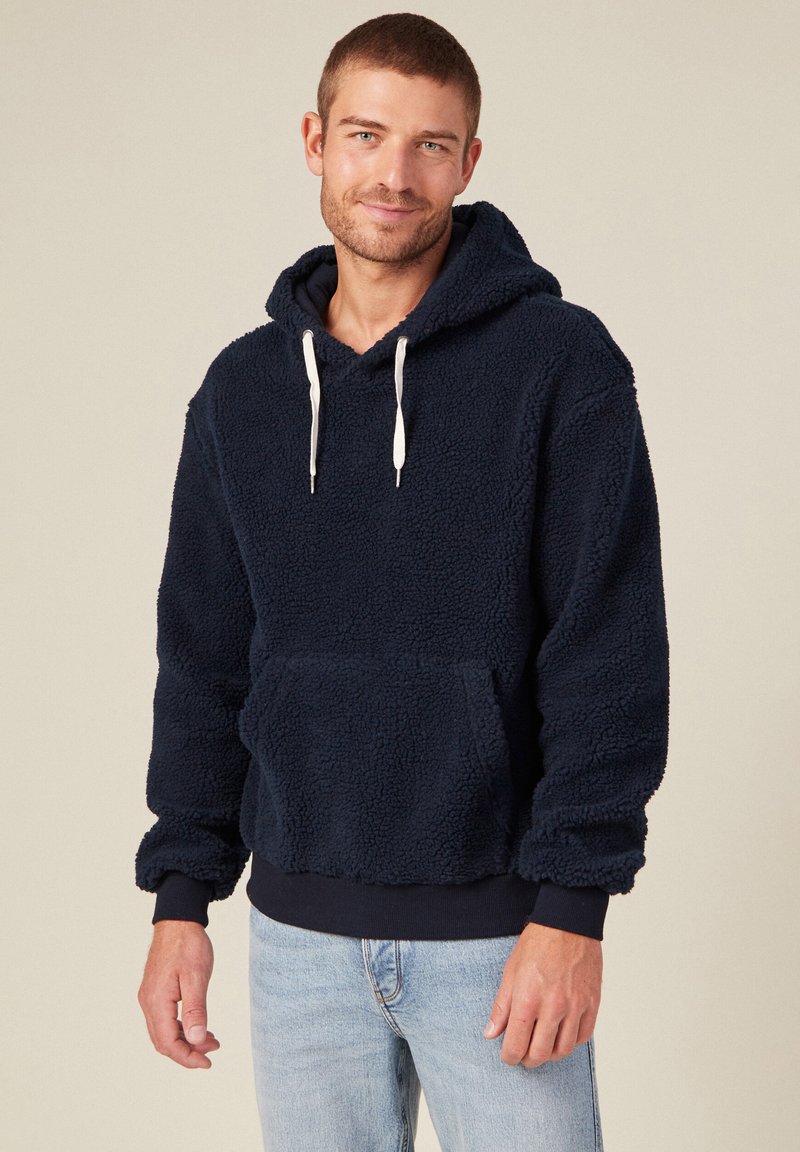 Hoodie en polaire bleu marine avec une texture douce, capuche à cordon, poche kangourou à l'avant et poignets et ourlet côtelés. Design décontracté, longueur moyenne.