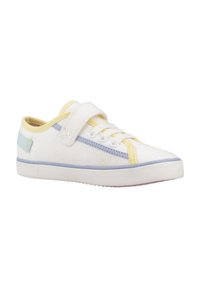 Zapatilla de lona blanca con detalles en amarillo y azul, cierre de cordones y velcro, punta redondeada, suela de goma texturizada y costuras en contraste.
