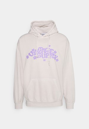 Felpa beige con tasca frontale, cappuccio con coulisse e testo "VINTAGE SUPPLY" in viola con accenti floreali. Tessuto morbido e casual con polsini a coste.