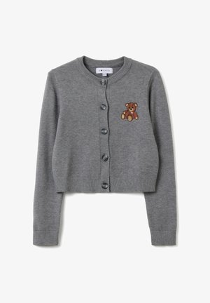 Gilet court gris en tricot doux. Présente une fermeture à boutons et un ours en peluche marron brodé sur la poitrine gauche.