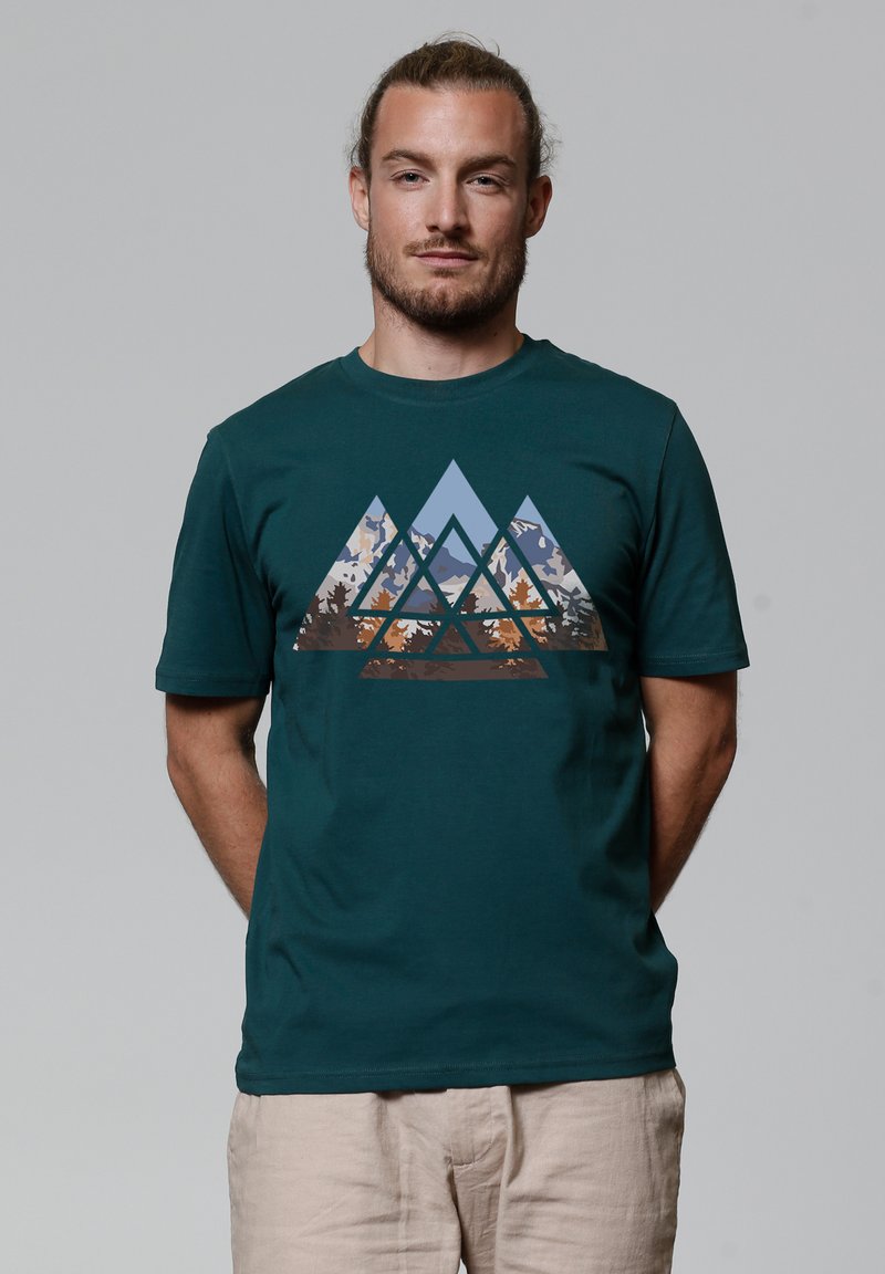 Teal katoenen t-shirt met een geometrisch bergontwerp in tinten blauw, bruin en tan, met een zachte textuur en korte mouwen.