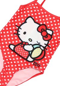 Maillot de bain à pois rouges avec un grand design de Hello Kitty tenant un ballon de plage. Le tissu est lisse et extensible, avec des bretelles transparentes.