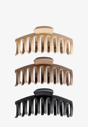 Pinzas de plástico para el cabello en tres tonos: beige claro, marrón medio y negro. Cada una presenta un diseño curvado con aberturas verticales y bordes redondeados.