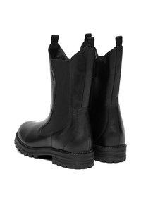 Para czarnych skórzanych butów do połowy łydki z elastycznymi panelami bocznymi, pętelkami do ściągania, solidnymi podeszwami i widocznym przeszyciem na krawędziach podeszw.