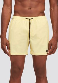 Pantaloni da bagno gialli realizzati in tessuto leggero, con vita elastica e cordino nero, di colore uniforme e un piccolo logo.