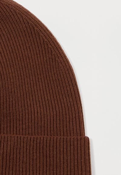 Gorro de punto marrón con textura acanalada. Presenta un dobladillo en la parte inferior, mostrando una transición suave en los patrones de tejido.