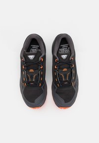 Scarpe da ginnastica nere con accenti arancioni, parte superiore in rete e suola in gomma texturizzata. Presentano un collare imbottito e un sistema di chiusura sicuro.