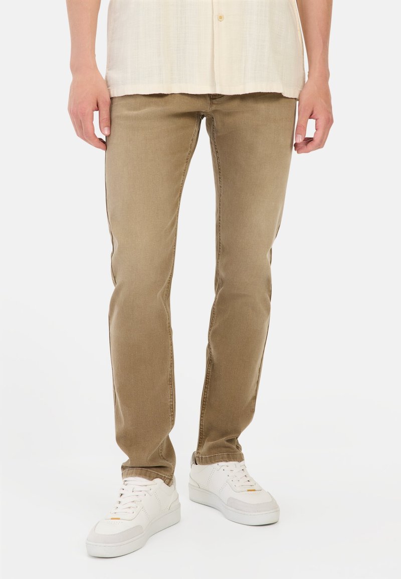 Beige straight-leg jeans met een zachte textuur, vijf zakken en een design met een gemiddelde taille, gecombineerd met witte sneakers.