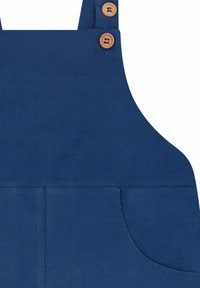 Grembiule in velluto a coste blu con due bottoni di legno sulla tracolla e una tasca frontale sul lato destro.