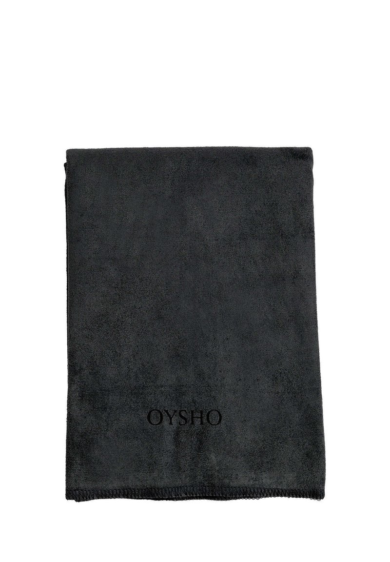 Črn, mehak brisača iz teksturirane tkanine, z robom, ki je šivan, in subtilnim logotipom "OYSHO" na eni strani. Pravokotna oblika.