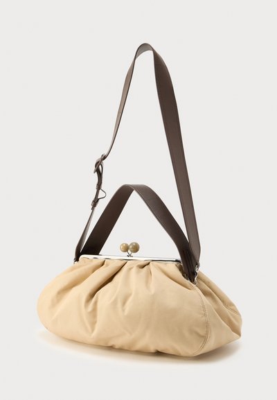 Μπεζ υφασμάτινη τσάντα χειρός με συγκεντρωμένο σχέδιο, ασημί κούμπωμα και δύο διακοσμητικές στρογγυλές χάντρες. Διαθέτει καφέ ρυθμιζόμενο ιμάντα ώμου.