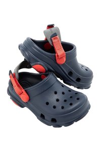 Námořnické sabatony s červenými akcenty vyrobené z lehkého materiálu. Obsahují větrací otvory a popruh pro bezpečné upevnění.