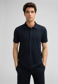 Navyblaues Poloshirt aus einem glatten, weichen Stoff. Verfügt über einen klassischen Kragen, eine Drei-Knopf-Leiste und ein kleines Logo im Brustbereich.