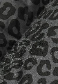 Țesătură neagră rezistentă la apă, cu un model de leopard umed, prezentând pete într-o nuanță mai închisă de negru și picături de apă vizibile.