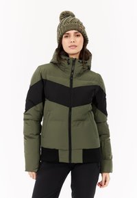 Olijfgroene pufferjack met zwart chevrondesign, ritssluiting en ribgebreide manchetten. Vergezeld van een olijfkleurige gebreide beanie met textuur.