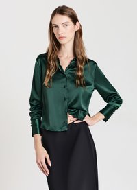 Green satin blouse with a button-up front, pointed collar, and long sleeves, featuring a smooth texture and structured fit.