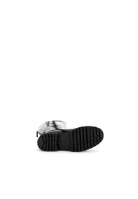 Botas de goma negras con suela texturizada y ligero tacón, con un material superior transparente brillante y cordones negros finos.