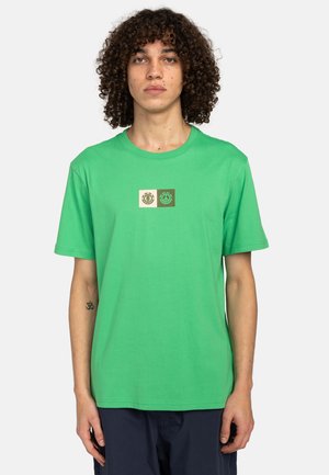 T-shirt in cotone verde con scollatura rotonda, maniche corte e un design grafico con tre loghi rettangolari in beige e verde scuro.