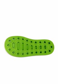 Suola di scarpa in gomma verde con motivi texturizzati circolari e ovali, con un design in rilievo e un bordo bianco liscio.