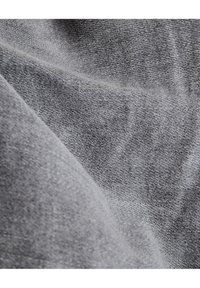 Tejido gris tejido con una textura suave, que presenta un sutil patrón jaspeado. El material parece ligero y se drapea de manera fluida.