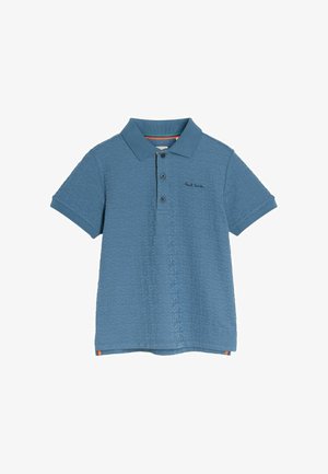 Mėlynos spalvos polo marškiniai su tekstūruotu "PS" raidžių raštu visame paviršiuje. Marškiniai turi klasikinius apykaklės kraštus, sagų užsegimą ir daugiwarnahemį kraštą.