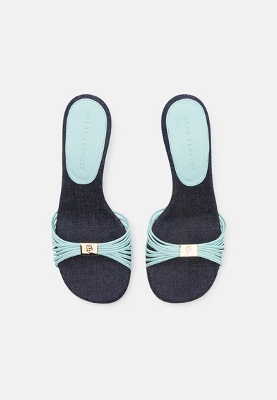 Denim sandals featuring an aqua strap with a gold accent. Smooth texture, open toe design, and a cushioned footbed for comfort.