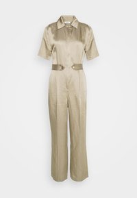 Combinaison satin beige à manches courtes, avec fermeture éclair à l'avant et taille ceinturée ornée d'accents en métal circulaire. Jambes de pantalon évasées.