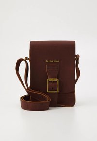 Brown leather crossbody bag with gold hardware, featuring a front flap and an adjustable strap. The surface is textured with visible stitching.
