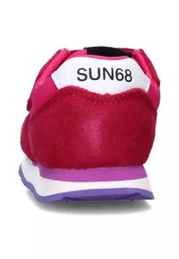 Sneaker in suede rosa con un tallone bianco recante il logo "SUN68", suola viola e lacci rosa. Sono visibili superfici lisce e texture.