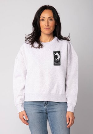 Hellgrau Sweatshirt mit Rundhalsausschnitt, oversized Passform und langen Ärmeln. Mit einem schwarzen Grafikdesign auf der Vorderseite.