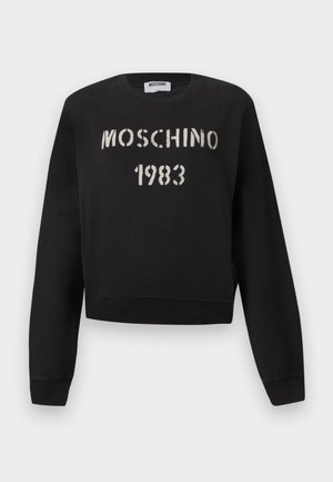 Zwarte Moschino-trui met geribbelde manchetten en zoom, voorzien van witte stencilstijl "MOSCHINO 1983" tekst op de voorkant.