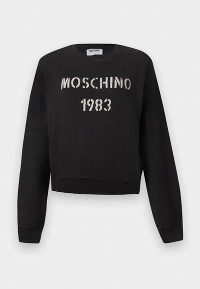 Μαύρο φούτερ Moschino με ριμπ μανσέτες και τελείωμα, με άσπρο κείμενο "MOSCHINO 1983" σε στυλ στένσιλ στο μπροστινό μέρος.