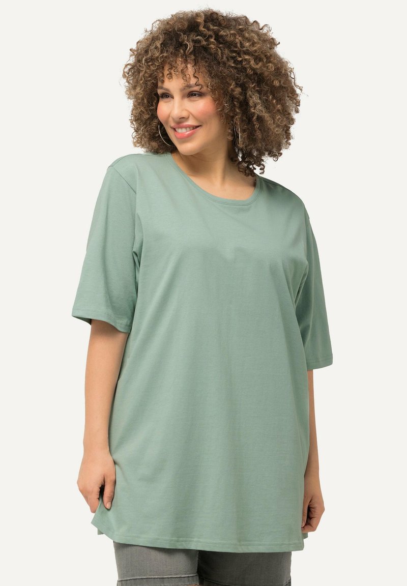T-shirt verde chiaro a maniche corte realizzato in tessuto morbido e liscio. Presenta una scollatura rotonda e una vestibilità rilassata e oversize.