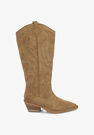 Bota vaquera de ante marrón con punta afilada, costuras decorativas y tacón apilado. Presenta una tira de agarre para facilitar su uso.