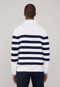 Maglione a collo rotondo in bianco con strisce orizzontali blu navy. Presenta polsini e orlo a coste, un tessuto testurizzato e una vestibilità rilassata.