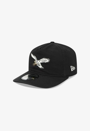 Black snapback cap with white embroidered eagle clutching a brown basketball on the front panel and a white logo on the side.