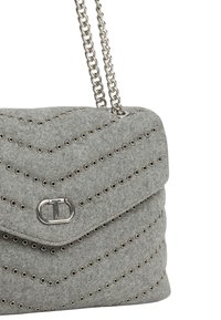 Borsa in feltro grigio con motivo a chevron, accessori argentati e dettagli con borchie. Dotata di tracolla a catena e chiusura con patta piegata.