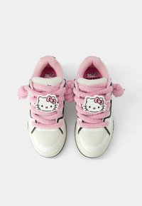 Bele teniske z rožnatimi puhastimi vezalkami in logotipom Hello Kitty na jeziku. Mrežasti in sintetični materiali; okrogla konica in raven podplat.