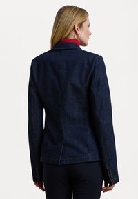 Temno modra jeans jakna s strukturiranim dizajnom, ovratnikom, dolgimi rokavi in gumbnimi detajli na manšetah. Prikazan zadnji pogled.